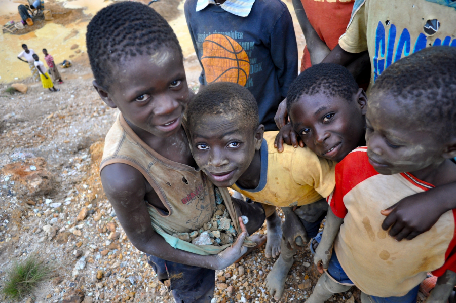 Dzieci pracujące w kopalni miedzi w Kongo prezentują wydobyte przez siebie rudy.